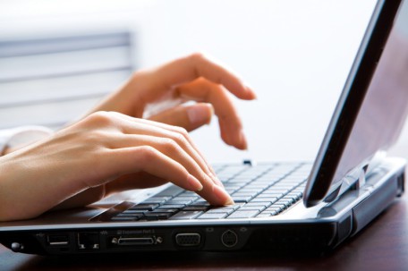 Image of female hands on the keys typing documents